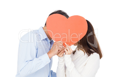 Lovely couple kissing behind big heart