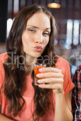 Woman looking at camera with shot in hand