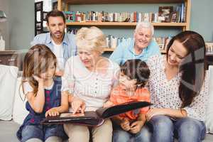 Smiling family with grandparents with photo album