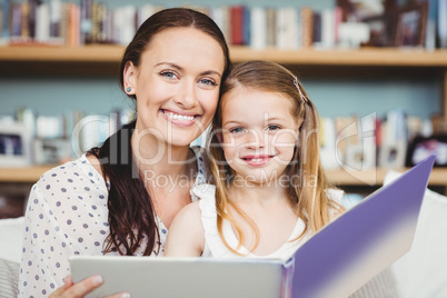 Close-up portrait of mother and daughter with book