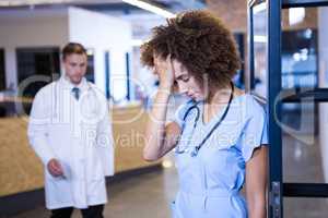 Tensed female doctor standing in hospital