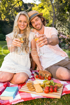 Happy couple having a picnic and drink champagne