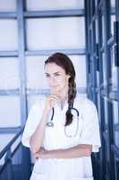 Thoughtful female doctor standing in hospital