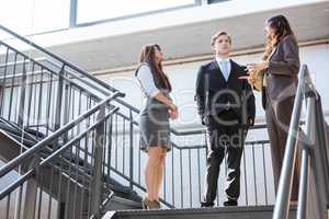 Three executives standing on a staircase