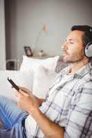 Man listening music while holding mobile phone