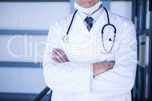 Male doctor standing with arms crossed