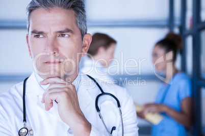 Thoughtful doctor standing in hospital