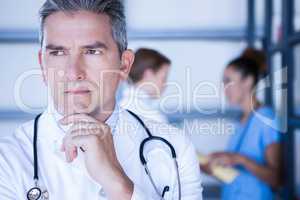 Thoughtful doctor standing in hospital