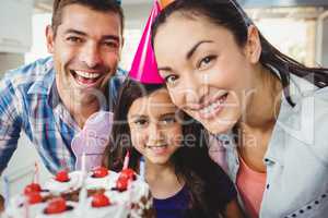 Portrait of cheerful family celebrating birthday at home