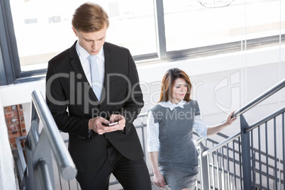 Businesspeople climbing staircase in office