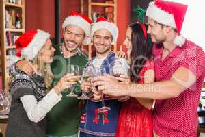 Friends with Christmas hats toasting