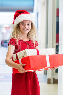 Portrait of a girl in Christmas attire standing with Christmas g