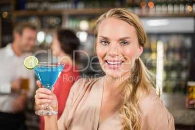 Attractive woman holding cocktail glass facing camera