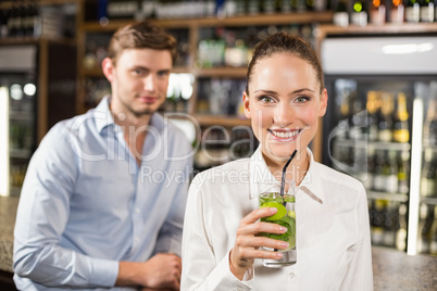 Woman drinking beverage in front of man