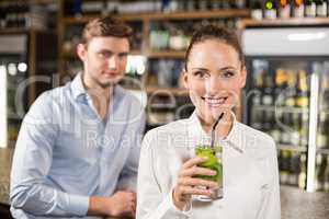 Woman drinking beverage in front of man