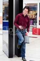 Man using a mobile phone outside a shop