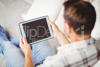 Rear view of man using digital tablet