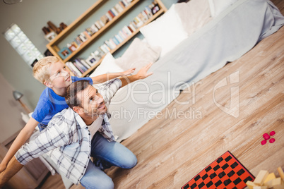 Tilt image of father and son playing on floor