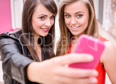 Two beautiful women taking a selfie on mobile phone