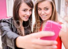 Two beautiful women taking a selfie on mobile phone