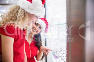 Mother and daughter in Christmas attire looking at wrist watch d