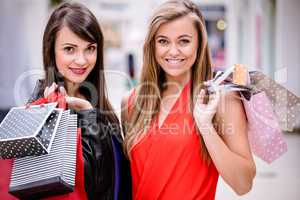 Portrait of two beautiful women shopping in mall