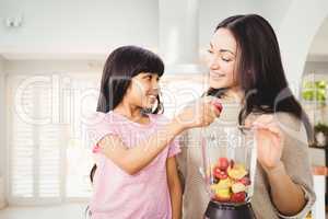 Mother and daughter preparing fruit juice