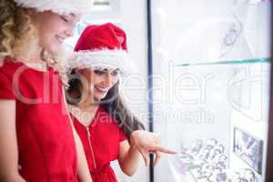 Mother and daughter in Christmas attire looking at wrist watch d
