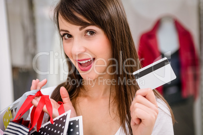 Portrait of happy woman showing her credit card while shopping