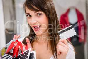 Portrait of happy woman showing her credit card while shopping