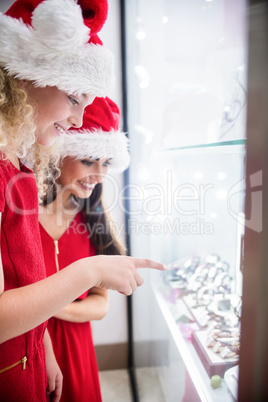 Mother and daughter in Christmas attire looking at wrist watch d