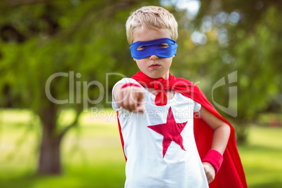 Little boy pretending to be superhero pointing