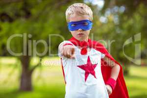 Little boy pretending to be superhero pointing