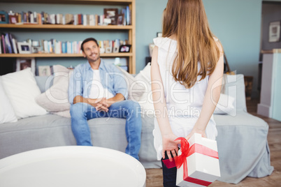 Daughter hiding gift box from father