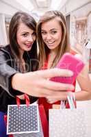 Two beautiful women taking a selfie in shopping mall