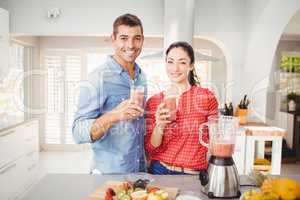 Portrait of smiling couple holding fruit juice