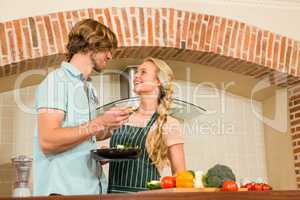 Handsome man making his girlfriend taste the preparation