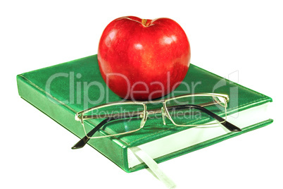 Apple and glasses on a book
