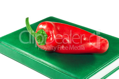 Red pepper on a green book