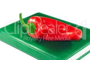 Red pepper on a green book