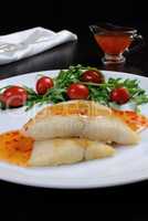 Flounder fillets in sauce with arugula and cherry tomatoes