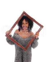 African American woman looking trough picture frame.