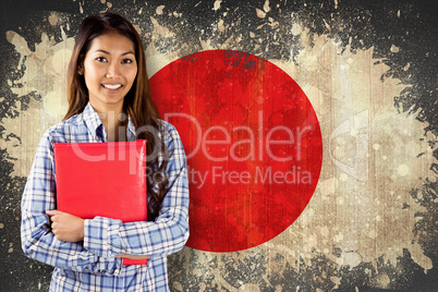 Composite image of smiling asian woman holding red book