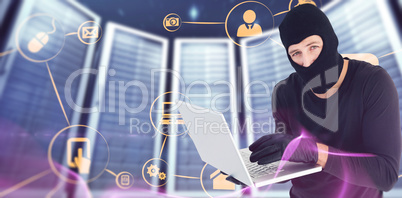 Composite image of burglar standing holding laptop while looking
