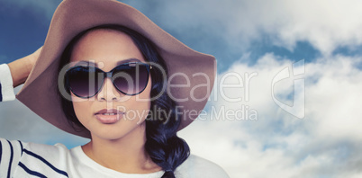 Composite image of attractive asian woman with hat and sunglasse