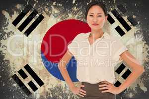 Composite image of asian businesswoman with hands on hips