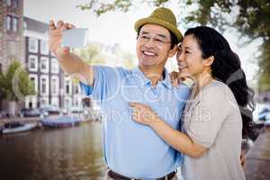 Composite image of man and woman taking a picture