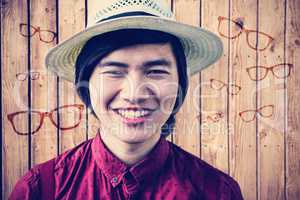 Composite image of smiling hipster with a straw hat