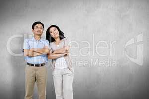 Composite image of smiling couple with arms folded