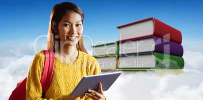 Composite image of smiling asian female student using tablet